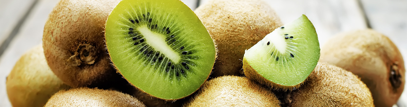 Kiwis on a table with some in halves and quarters