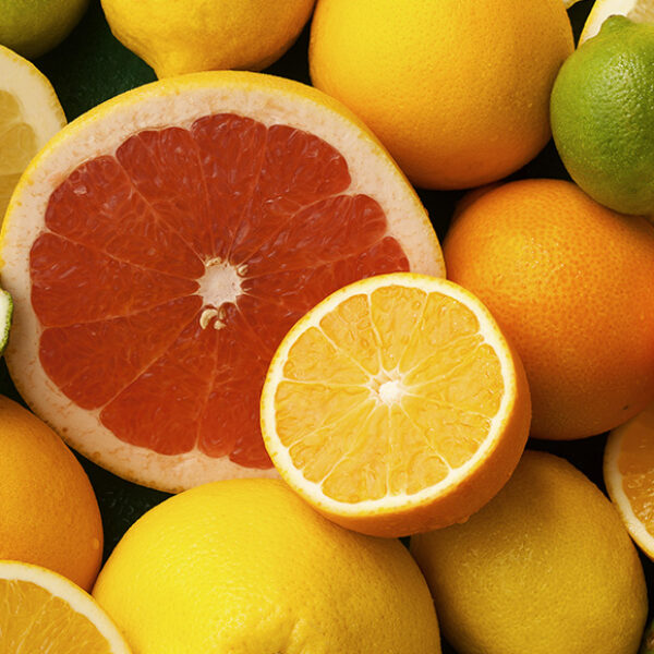 Lots of citrus fruit, with oranges and grapefruits sliced in half